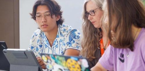 two students study with a 教师 member